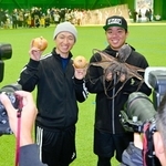 スポーツ紙のリクエストに応え、淡路島特産のタマネギと干しダコを手にする近本光司選手（左）と村上頌樹投手＝淡路佐野運動公園