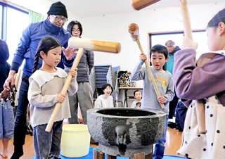 「明けましておめでとう」。新年のあいさつをし、餅をつく子どもたちを見守る堂本秀幸さん（左端）＝南あわじ市八木鳥井