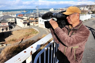 ３１年前、被災地にカメラを回した高台。再建された家並みに「歳月を感じる」と話す神子素孝輝さん＝淡路市斗ノ内