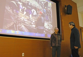 富島地区での救出作業を見ながら映像の活用について語る、北淡震災記念公園の大浅田恭典さん（右）と神子素孝輝さん＝淡路市小倉
