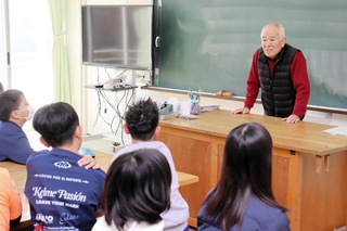 児童を前に、震災時の救助活動について語る高田一夫さん＝北淡小学校