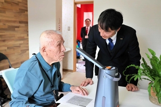 読書器で読み上げられた音声を聞く入居者＝五色園