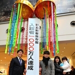 くす玉を割って入館１千万人達成を祝う荒川裕也さん一家（右）と戸田敦大市長＝淡路市小倉