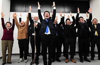 万歳三唱で当選を喜ぶ吉平敏孝氏（中央）と支援者ら＝洲本市栄町２