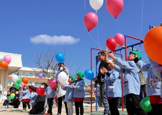 青空に向かって風船を飛ばす園児ら＝堺保育園