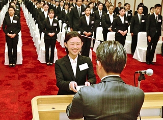 入社式で決意表明を読み上げた中家妃菜さん（中央）と新入社員＝ホテルニューアワジ