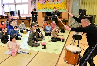 梶原徹也さん（右端）の演奏に合わせ、手製の太鼓をたたく参加者＝洲本市五色町広石北