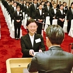 入社式で決意表明を読み上げた中家妃菜さん（中央）と新入社員＝ホテルニューアワジ