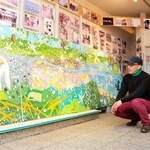 洲本の町をモチーフにした作品の前で「出会った人々を思いながら描いた」と話す山田宗宏さん＝洲本市本町８