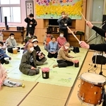 梶原徹也さん（右端）の演奏に合わせ、手製の太鼓をたたく参加者＝洲本市五色町広石北
