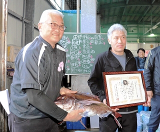 「壱番鯛」を落札し笑顔の上野賢次さん（左）と賞状を手にする中西一郎さん＝淡路市岩屋