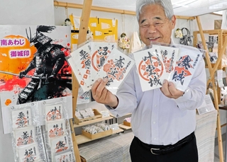 人気の「たまねぎ御城印」を手にする関口功さん。障害者の就労支援にもなっている＝南あわじ市志知鈩