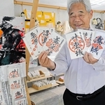 人気の「たまねぎ御城印」を手にする関口功さん。障害者の就労支援にもなっている＝南あわじ市志知鈩