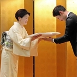 ニ代目を襲名し、かみしもを受け取る鶴澤友路さん（中央）＝南あわじ市阿万吹上町