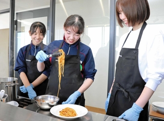 生パスタの製造や調理を体験する近野雅さん（中央）と長谷心花さん（左）＝淡路市生穂新島