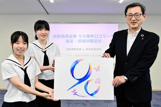 石田萌衣さん（左端）と土居叶乃さんからロゴのパネルを受け取る田所英司理事長＝洲本市下加茂１