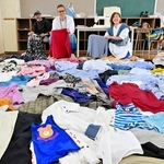 たくさんの古着を前に、リメークへのチャレンジを呼びかける（右から）清水かなよさん、増見喜一朗社長ら＝淡路市江井