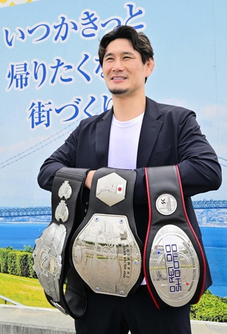 獲得した３本のベルトを手にする住村竜市朗さん。「いつか故郷に恩返しを」と話した＝淡路市役所