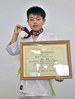 ３位のメダルと表彰状を手にする田中皐嗣さん＝南あわじ市役所