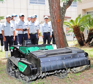 ラジコン草刈り機の操作を体験する淡路高校生＝淡路市富島
