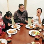 堂本秀幸さん（中央）が手作りした食事に笑顔を見せる子どもら＝南あわじ市八木鳥井