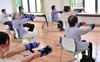 重りを使った「百歳体操」に取り組む利用者ら＝南あわじ市伊加利