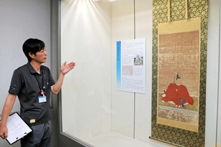 脇坂安治の肖像画（複製）などを紹介しながら、洲本城の歴史を解説する金田匡史館長＝洲本市山手１