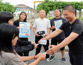 土生港でシールをプレゼントする沼島中学校の男子生徒と長坂美黎さん（右から４人目）＝南あわじ市灘土生