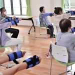 重りを使った「百歳体操」に取り組む利用者ら＝南あわじ市伊加利