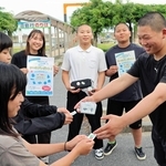 土生港でシールをプレゼントする沼島中学校の男子生徒と長坂美黎さん（右から４人目）＝南あわじ市灘土生