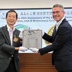 姉妹都市提携３０周年記念の瓦を手にする守本憲弘市長（左）とジェフリー・ヘーゼル市長＝南あわじ市役所