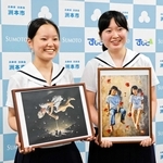 出品作の写真を手にする太田和花さん（左）と土居叶乃さん＝洲本市役所