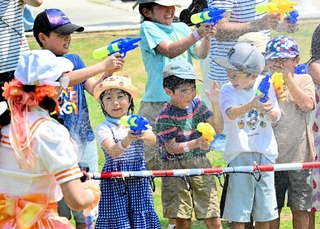 放水に負けず、水鉄砲で的を狙う子どもら＝淡路市塩田新島