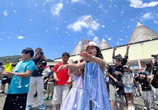 人口降雪機から噴き出す氷のつぶを浴びる子どもら＝淡路市塩田新島