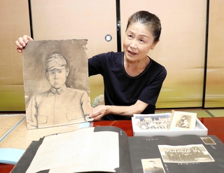 ルソン島に出征した伯父の肖像画を手に語る脇素子さん。遺品の写真からは幼少から学生時代の姿が浮かび上がる＝淡路市中田