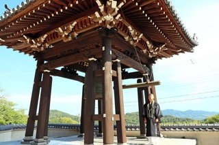 龍宝寺の鐘楼は柱が３本ずつある珍しい造り。「建て替えに関わった祖父はこだわりのある人だった」と話す平見隆典住職＝洲本市五色町鮎原葛尾