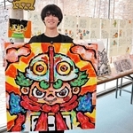 最新作を手に「カラフルな空間を楽しんで」と話す冨永大和さん＝洲本市塩屋１