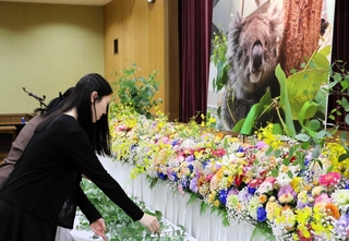 「のぞみ」のパネル写真にユーカリを手向けるお別れセレモニーの出席者＝南あわじ市八木養宜上