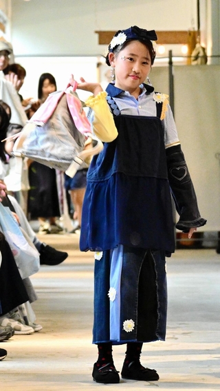 小さい頃に着ていた服をほどいて縫い直し、トップスとリュックに再生。スカートはパッチワークで仕上げ、思い出のアップリケを付けた＝淡路市江井