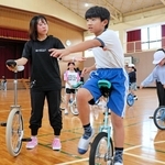 堀田綾菜さん（左端）の手ほどきで一輪車を練習する湊小学校の児童＝南あわじ市湊里