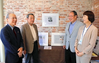 鬼頭梓さんの生誕１００年記念展示を企画した藤原成曉さん（左端）と語らう、（右から）洲本図書館の坂口祐希館長、浜辺学さん、山本優雄さん＝洲本市塩屋１