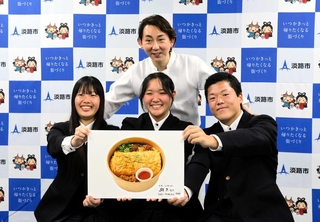 小野孝太さん（後ろ）の監修で開発した「淡路丼」の写真を手にする淡路高生徒＝淡路市役所