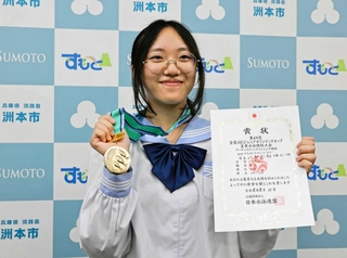 メダルと賞状を手に優勝を報告する巽早希さん＝洲本市役所
