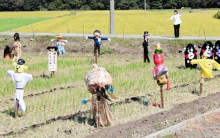 田園風景に並ぶユニークなかかし＝南あわじ市伊加利