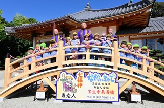 長寿橋の完成を祝う十輪地弘光住職（後列中央）と園児ら＝淡路市里