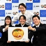 小野孝太さん（後ろ）の監修で開発した「淡路丼」の写真を手にする淡路高生徒＝淡路市役所