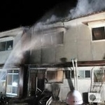 集合住宅に放水する消防署員ら＝２４日午前４時１分、姫路市