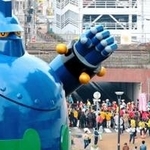 震災復興の象徴でもある鉄人２８号のモニュメント脇を通るコース。沿道の応援を受けてランナーが走る＝神戸市長田区若松町６