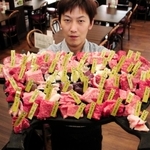 但馬牛を１頭丸ごとさばいた６１部位を食べ比べできるバーベキューメニューをＰＲする石原亮さん＝道の駅「村岡ファームガーデン」