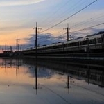 水を張った田んぼの間を走る電車＝三田市桑原